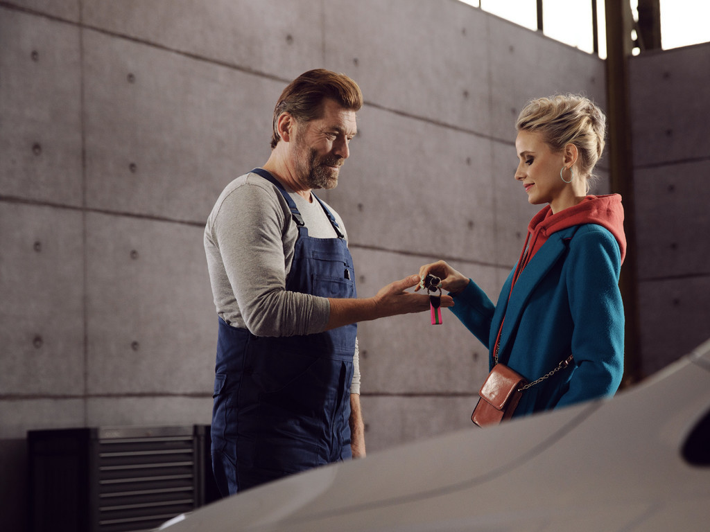 Una donna consegna le chiavi della propria auto a un addetto Volkswagen Service